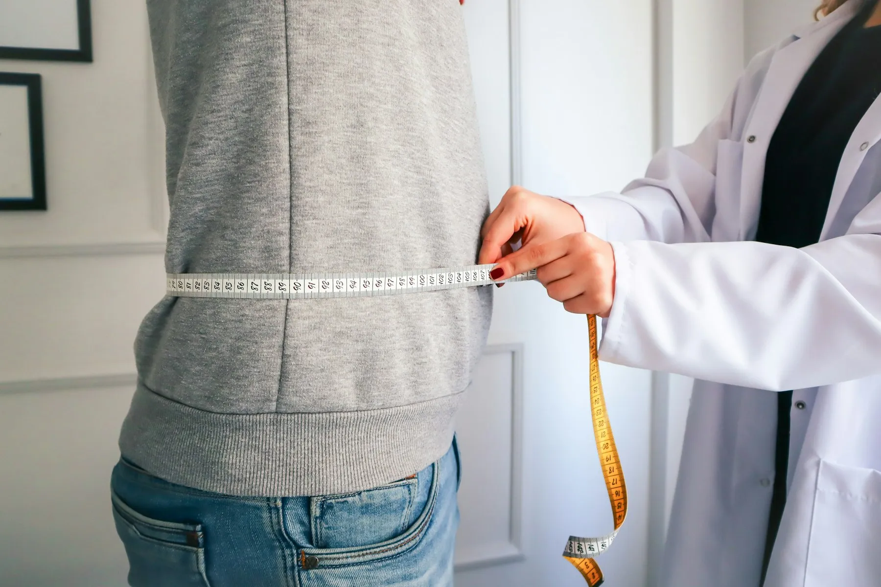 Medición de cintura con centímetro en una consulta